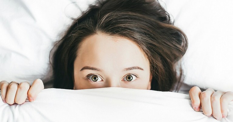 Pavor nocturnus: Frau mit braunen Haaren liegt im Bett, Symbolbild fr Nachtschreck