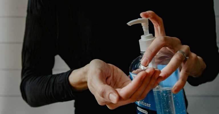 Hände desinfizieren mit Desinfektionsmittel aus Spenderflasche