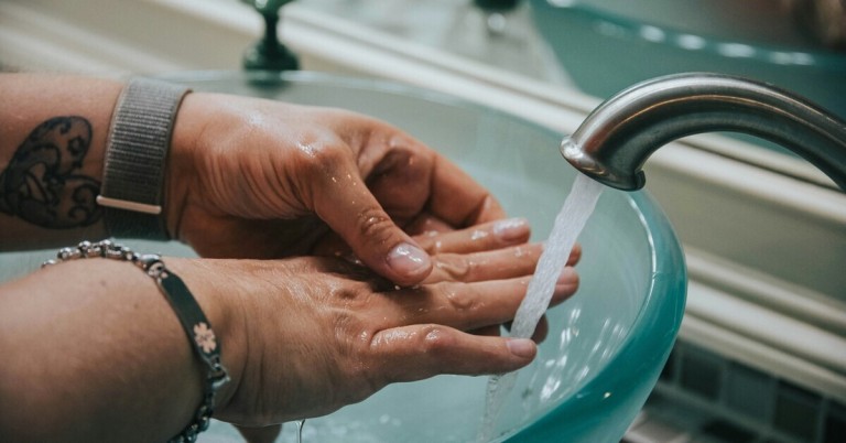 Hände waschen unter fließendem Wasser am Waschbecken