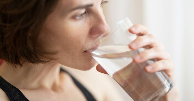 Person trinkt ein Glas Wasser