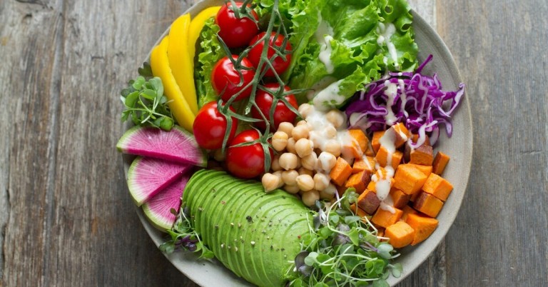 Bunte gesunde Ernährung mit frischem Gemüse, Kichererbsen, Avocado und Salat in einer Schüssel