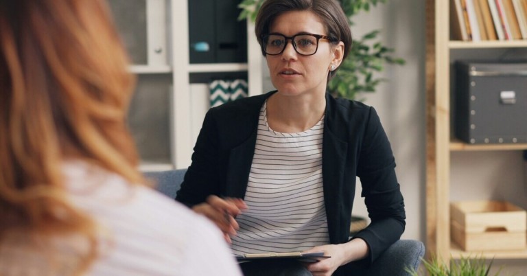 Therapeut im Gespräch mit einer Patientin in einer modernen Praxis